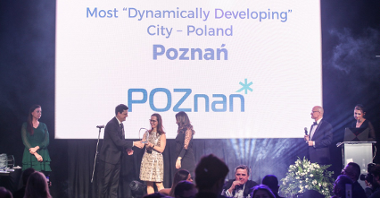 Obrazek jest zdjęciem z gali. W tle na wielkim ekranie widać napis: "Most Dynamically Developing City - Poland. Poznań". Przed ekranem stoją osoby prowadzące galę. Wręczają nagrodę Biuru Obsługi Inwestora.