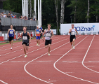 Zdjęcie przedstawia młodzież biegnącą po bieżni.